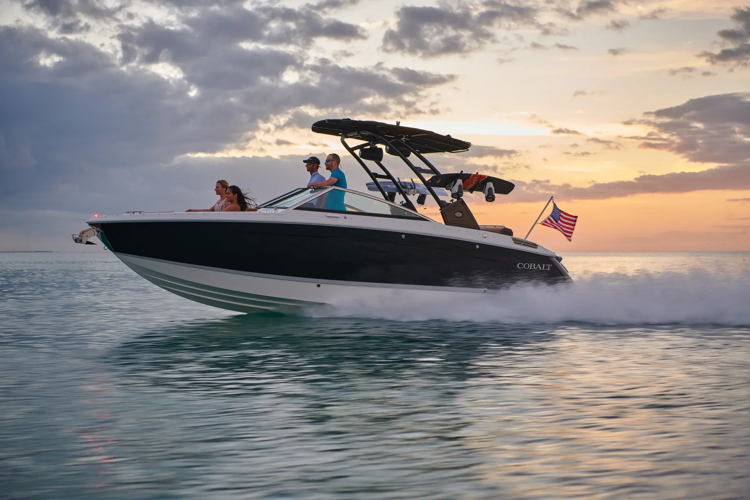 Family cruising on a Cobalt boat at sunset
