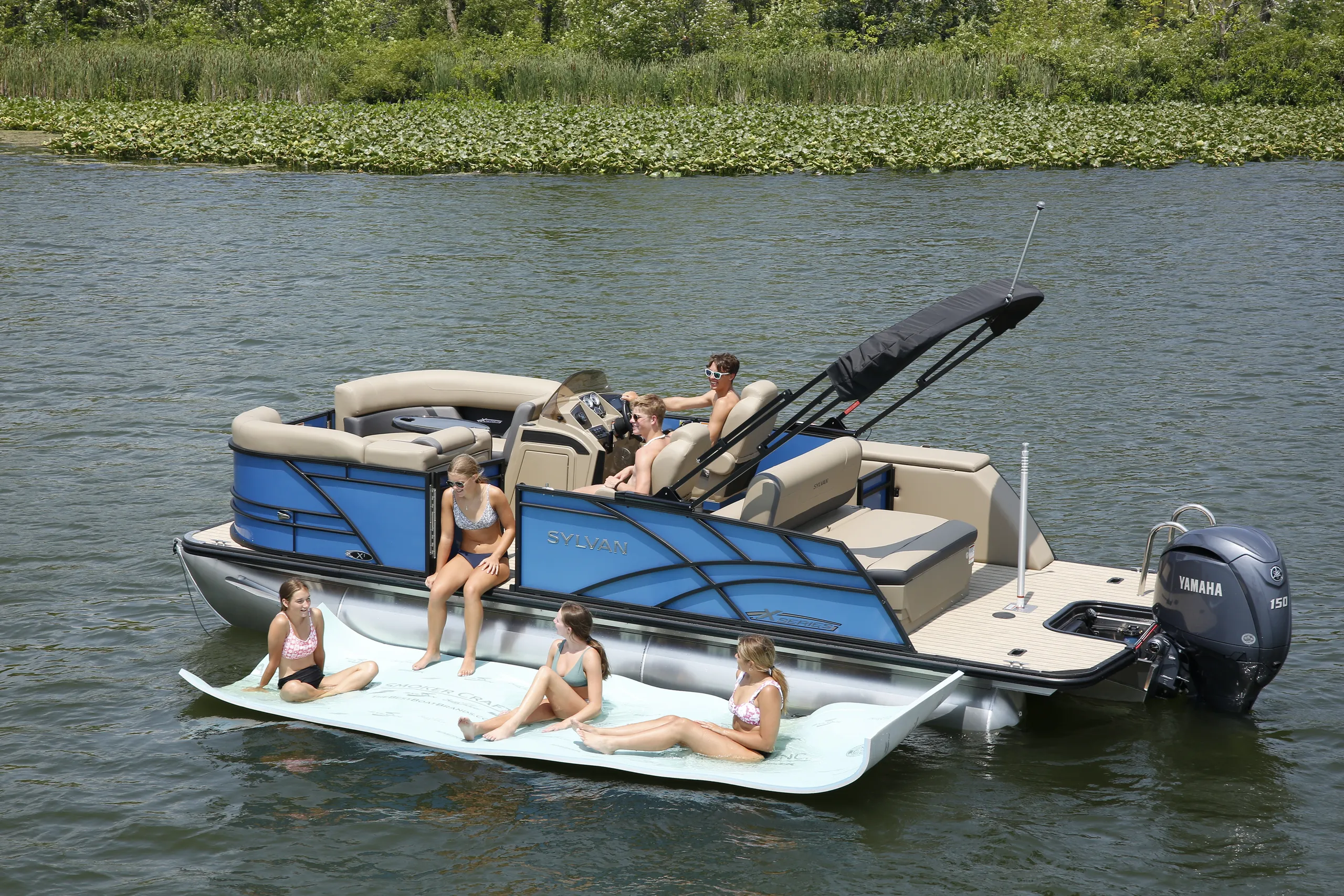 Family relaxing beside a Sylvan pontoon at a sandbar